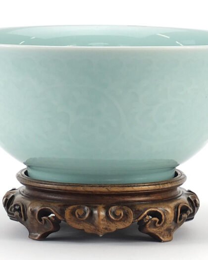 Chinese celadon bowl on a carved hardwood stand