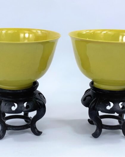 Pair of Chinese imperial yellow rice bowls on hardwood stands