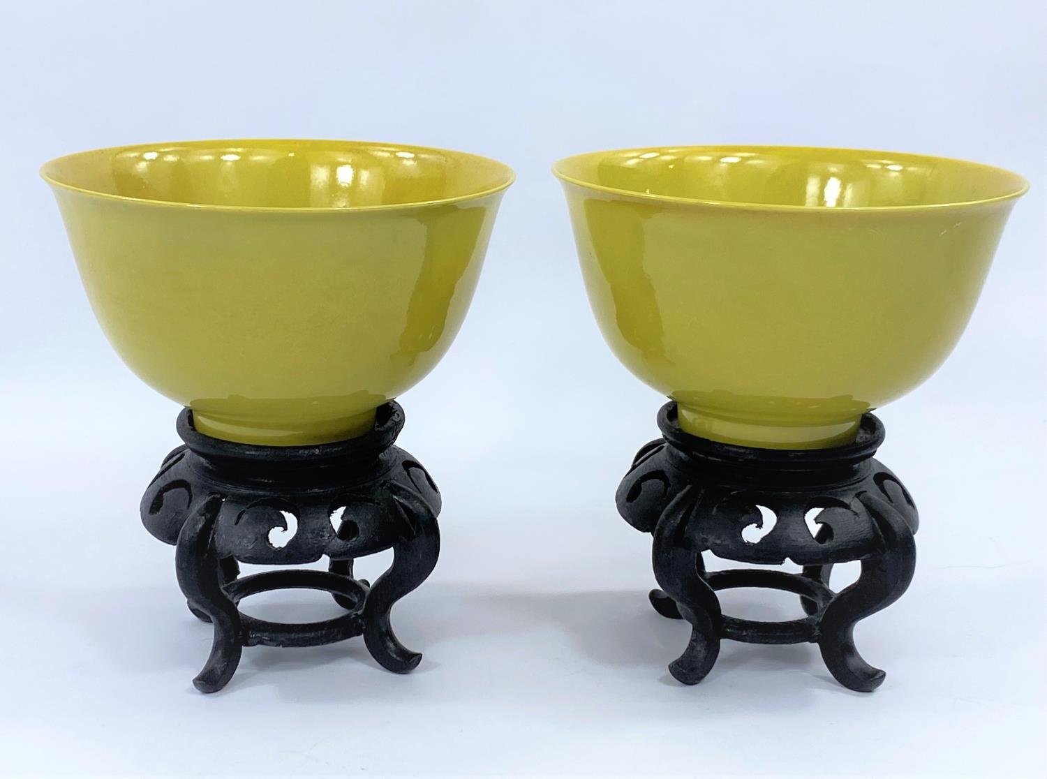 Pair of Chinese imperial yellow rice bowls on hardwood stands