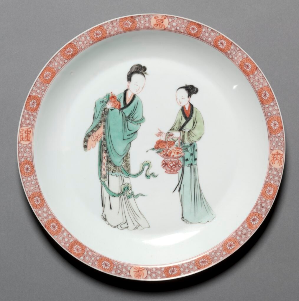 Famille verte porcelain dish painted with a lady and an attendant inside an iron-red diaper border, Kangxi mark and period. Cleveland Museum of Art, 1964.220.