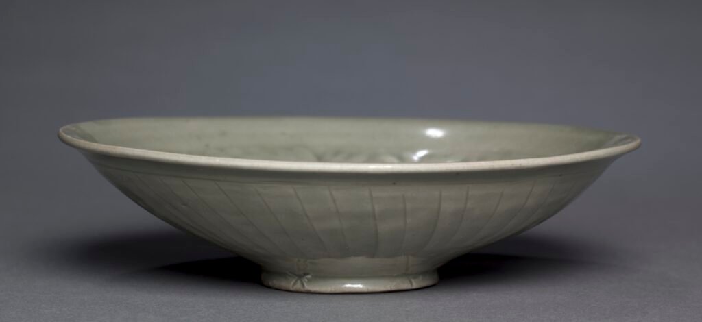 Shallow Yaozhou ware bowl with moulded peonies under an olive-green glaze, Jin dynasty, twelfth century. Cleveland Museum of Art, 2001.107.