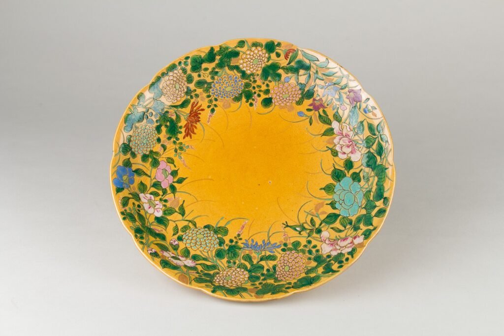 Dish with overglaze enamels painted over a yellow glaze, Jingdezhen, Qianlong period 1736 to 1795. The Metropolitan Museum of Art, accession 79.2.563, Open Access.